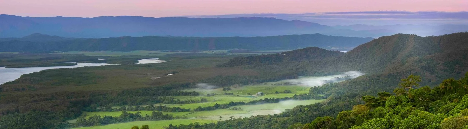 Douglas Shire at first light: cane flats, the river and rainforest ridges under a pink sky